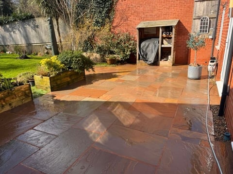 Wet patio with mixed terracotta and slate tiles after professional cleaning