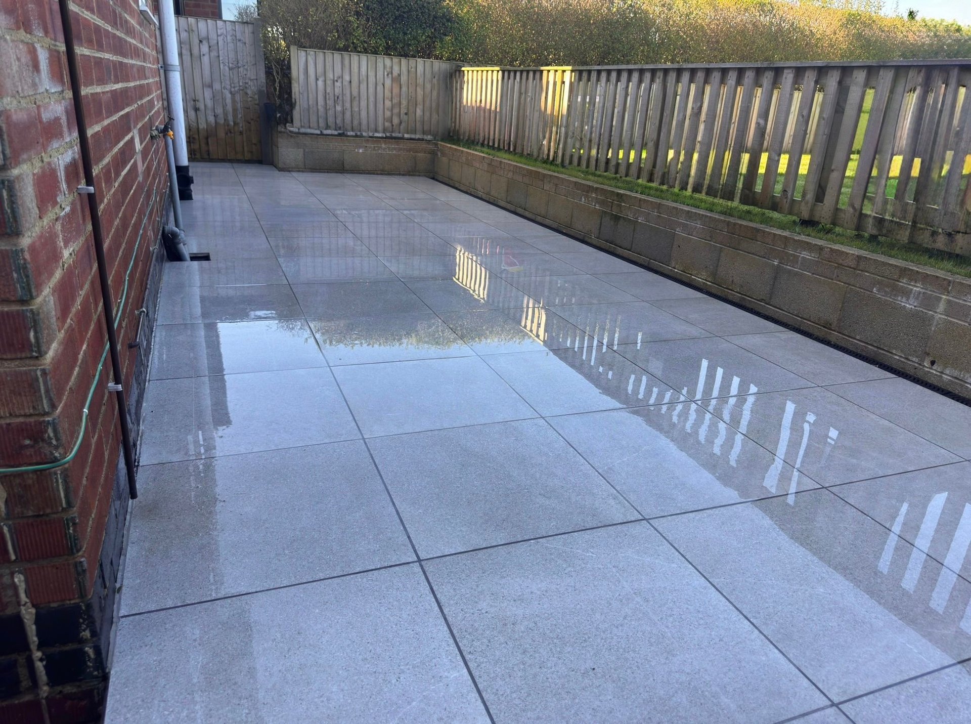 Empty residential patio with gray paving stones and wooden fencing